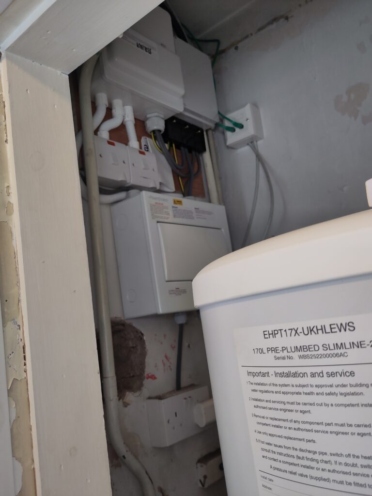 Electrical board work complete, with hot water tank in foreground.